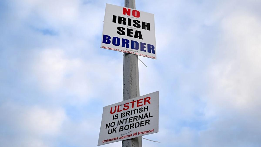Các biển báo ghi "Không có biên giới Biển Ailen" và "Ulster là thuộc Anh, không có Biên giới nội bộ Vương quốc Anh" được dán trên một cột đèn tại Cảng Larne, Bắc Ireland. Ảnh: Rueters (chụp ngày 6/3/2021).