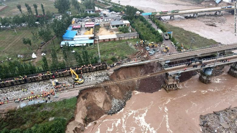 Lực lượng cứu hộ sửa chữa một cây cầu bị hư hại do lũ lụt vào ngày 7/10/2021, ở Tấn Trung, tỉnh Sơn Tây. Ảnh: CNN