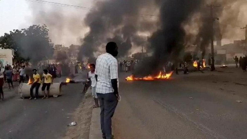 Mọi người tụ tập khi lửa và khói được nhìn thấy trên đường phố Kartoum, Sudan, giữa các báo cáo về một cuộc đảo chính, ngày 25/10/2021. Ảnh: Reuters (chụp qua video trên mạng xã hội)