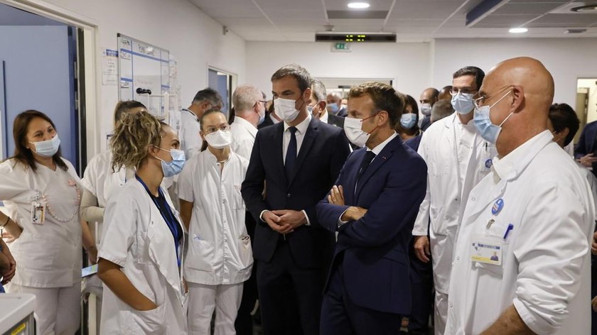 Tổng thống Pháp Emmanuel Macron và Bộ trưởng Y tế Olivier Veran nói chuyện với các nhân viên y tế trong chuyến thăm bệnh viện La Timone, ở Marseille, Pháp. Ảnh: Pool phát qua Reuters