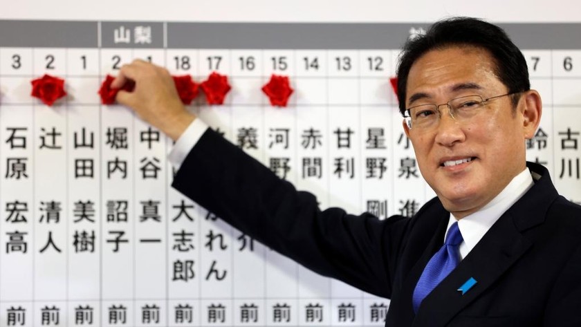 Thủ tướng Nhật Bản và lãnh đạo Đảng Dân chủ Tự do (LDP) cầm quyền Fumio Kishida đặt hoa hồng có tên các ứng cử viên tổng tuyển cử thành công lên bảng tại trụ sở đảng ở Tokyo ngày 31/10/2021. Ảnh: Pool via AP