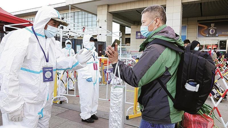 Một nhân viên kiểm soát dịch bệnh kiểm tra mã sức khỏe của một hành khách tại lối ra ga đường sắt ở Yên Đài, tỉnh Sơn Đông ngày 1/11/2021. Ảnh: China Daily