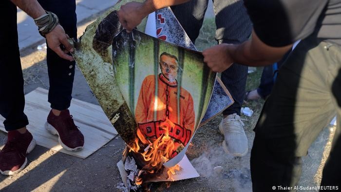 Những người ủng hộ dân quân đốt chân dung của Thủ tướng al-Khadimi khi tuần hành đến gần Vùng Xanh. Ảnh: Reuters