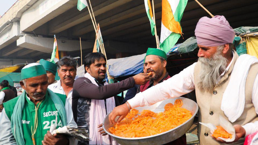 Những người nông dân tại địa điểm biểu tình của nông dân Ghazipur gần biên giới Delhi-UP chia kẹo ăn mừng sau khi Thủ tướng Ấn Độ Narendra Modi thông báo rằngsẽ bãi bỏ 3 đạo luật về nông nghiệp ngày 19/11/2021. Ảnh: Reuters