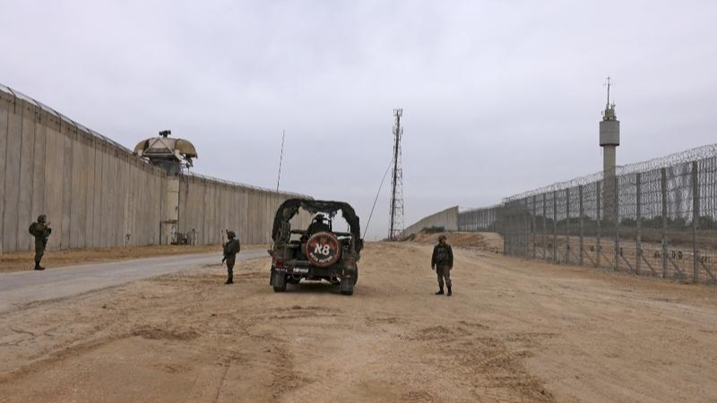 Các binh sĩ Israel đứng gác bên hàng rào dọc biên giới với Dải Gaza gần Moshav Netiv HaAsara ở miền nam Israel vào ngày 7/12/2021. (Ảnh: AFP