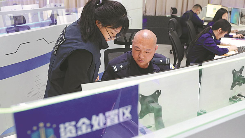 Các nhân viên cảnh sát làm việc tại trung tâm chống gian lận ở Đại Hưng. Ảnh: China Daily