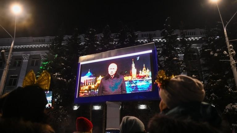 Mọi người xem video Tổng thống Nga Vladimir Putin đưa ra thông điệp năm mới ở Kemerovo, Nga, ngày 31/12/2021. Ảnh: Sputnik
