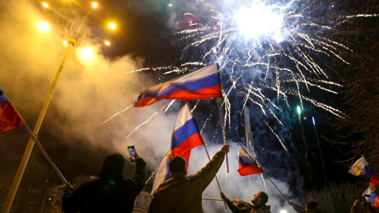 Người dân ở Donetsk, miền Đông Ukraine vẫy cờ Nga mừng được công nhận độc lập tối 21/2/2022. Ảnh: AP