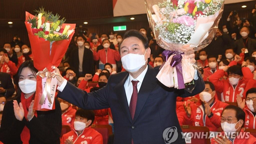 Tổng thống đắc cử Yoon Suk-yeol chụp ảnh sau khi nhận hoa trong phòng bầu cử của đảng mình tại Quốc hội ở Seoul vào ngày 10/3/2022. Ảnh: Yonhap