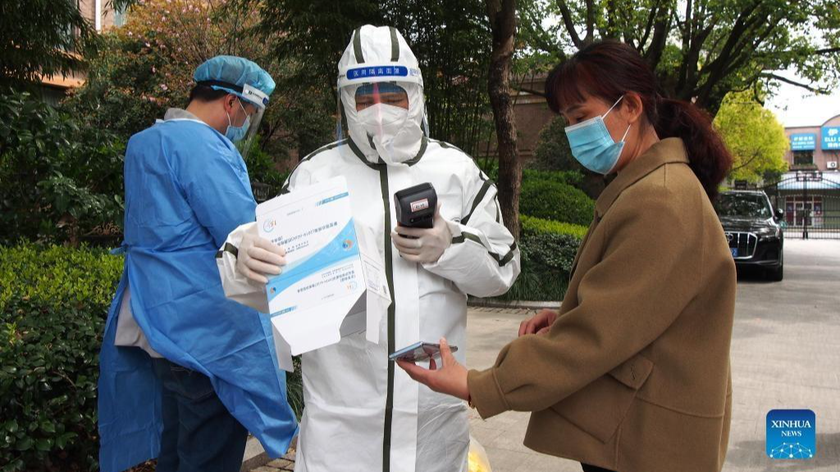 Một nhân viên y tế đăng ký thông tin của một người dân để làm xét nghiệm COVID-19 tại một cộng đồng dân cư ở quận Minhang, Thượng Hải ngày 1/4/2022. Ảnh: Tân Hoa xã