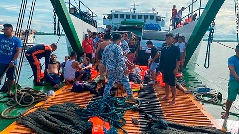 Lực lượng bảo vệ bờ biển Philippines kiểm tra các hành khách được giải cứu tại cảng Real ở tỉnh Quezon ngày 23/5. Ảnh: CNN