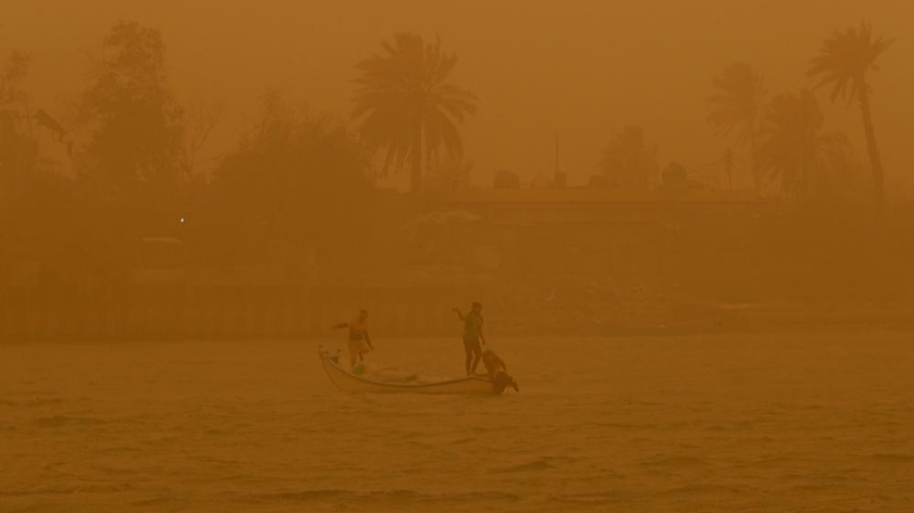 Ngư dân di chuyển trên đường thủy Shatt al-Arab trong trận bão cát ở Basra, Iraq, ngày 23/5/2022. Ảnh: AP