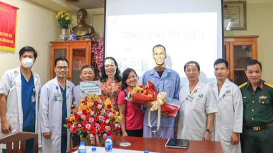 Các bác sĩ trao giấy ra viện, tặng hoa chúc mừng bệnh nhân khỏi bệnh - Ảnh: Hoài Thương