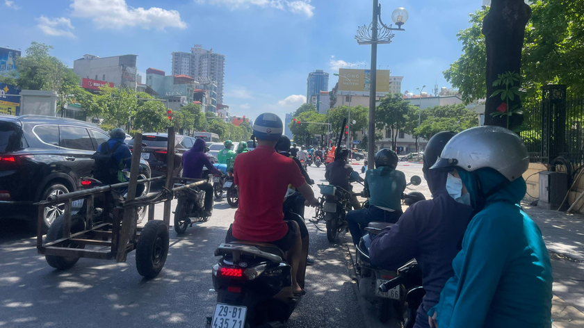 Nắng nóng, người dân chọn bóng râm ven đường để dừng xe khi chờ đèn đỏ - Ảnh: Minh Trang