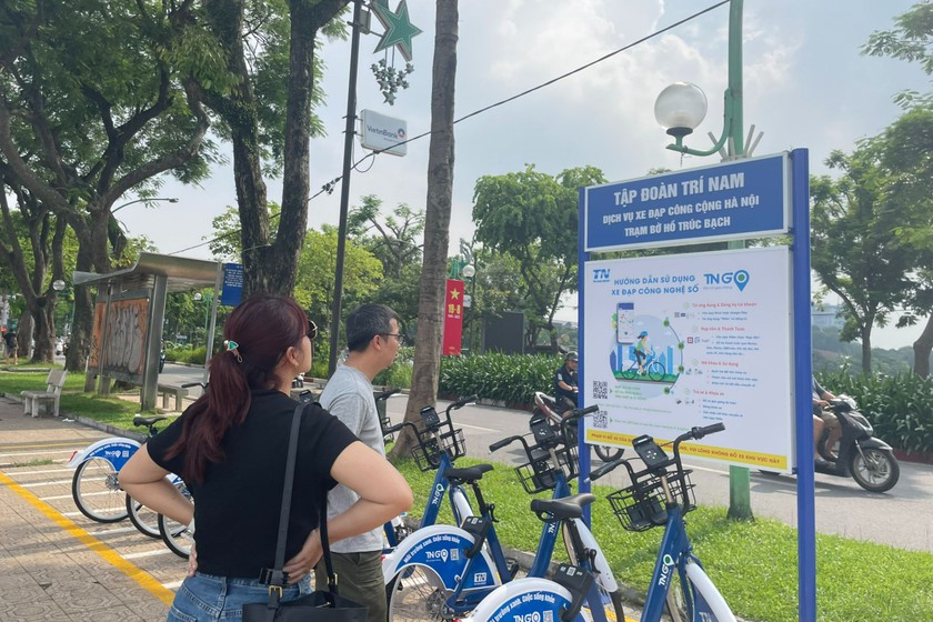 Người Hà Nội tìm hiểu cách sử dụng xe đạp điện công cộng. Ảnh: Minh Trang