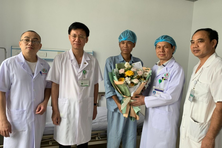 Lãnh đạo bệnh viện cùng các bác sĩ, điều dưỡng chăm sóc bệnh nhân gửi hoa chúc mừng bệnh nhân ra viện.
