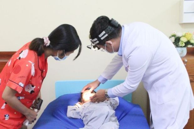 Bé gái được bác sĩ thăm khám sau khi phẫu thuật lấy dị vật là mảnh cục pin ra khỏi hốc mũi.