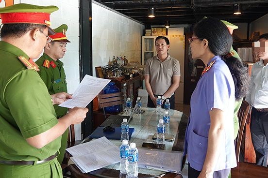 Cơ quan điều tra tống đạt các quyết định đối với ông Nguyễn Công Kính (áo nâu, đứng giữa). Ảnh: Công an Bình Thuận