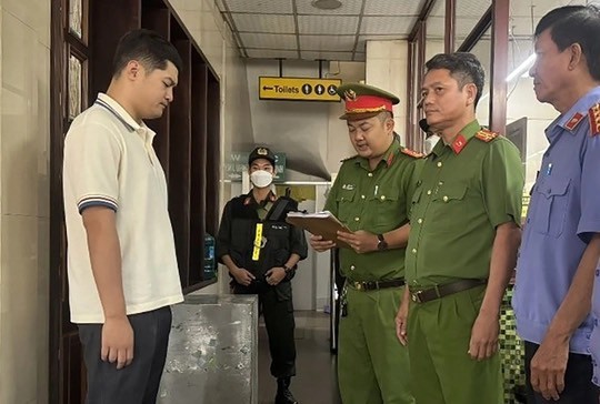 Cơ quan chức năng đọc lệnh bắt giữ Lê Dương - Ảnh: Báo Chính phủ