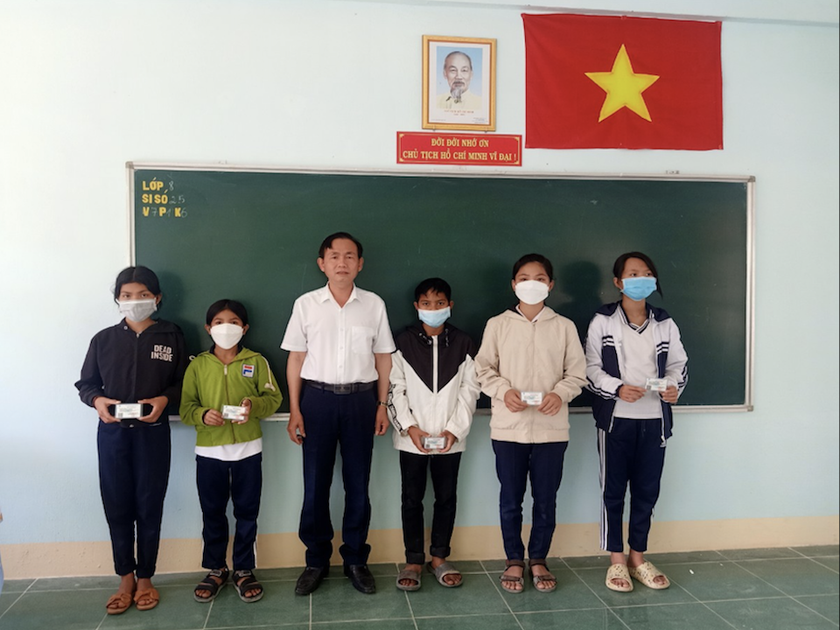 Đại diện cán bộ trường THCS Nguyễn Huệ trao tặng thẻ BHYT cho học sinh trường THCS Chư Hreng, xã Chư Hreng, TP. Kon Tum.