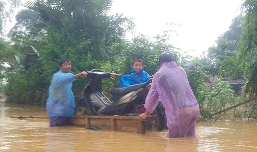 Các em nhỏ được bố mẹ đưa đi chạy lũ. Toàn huyện Hương Khê có 3 trường học bị ngập, hơn 4.600 học sinh 3 cấp phải nghỉ học.Ảnh: VnExpress
