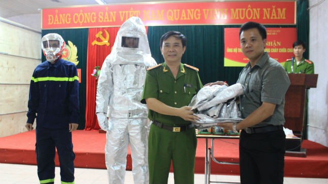 Đại tá Trần Văn Vụ - Trưởng phòng Cảnh sát PC&CC tiếp nhận thiết bị bảo hộ PCCC từ công ty TNHH TM XNK Ngọc Vũ