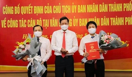 Phó Chủ tịch Thường trực UBND TP Lê Anh Quân trao quyết định bổ nhiệm, tặng hoa chúc mừng các ông Phạm Hưng Hùng và Nguyễn Ngọc Tú. Ảnh: CTTĐTTP