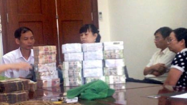 Ông Đinh Ngọc Uyên, Phó Giám đốc Côgn ty TNHH MTV Cảng Quảng Ninh (áo trắng ngồi đầu bên phải) giao nộp tiền cho cơ quan chức năng 