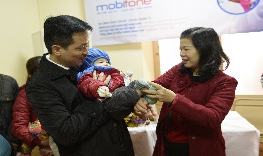 Ông Nguyễn Mạnh Hùng, Phó TGĐ Tổng công ty Viễn thông MobiFone, bà Lê Tuyết Mai - Phó GĐ Quỹ Bảo trợ Trẻ em Việt Nam chụp ảnh cùng một bệnh nhi trong chương trình