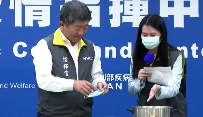 Bộ trưởng Y tế Đài Loan Chen Shih- chung (trái) trình diễn cách khử trùng khẩu trang bằng nồi hấp. 