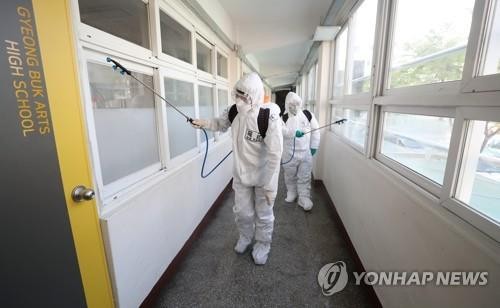 Quân y đang khử trùng một hành lang bên trong trường trung học nghệ thuật Gyeong Buk ở Daegu , ngày 14/4/2020. 