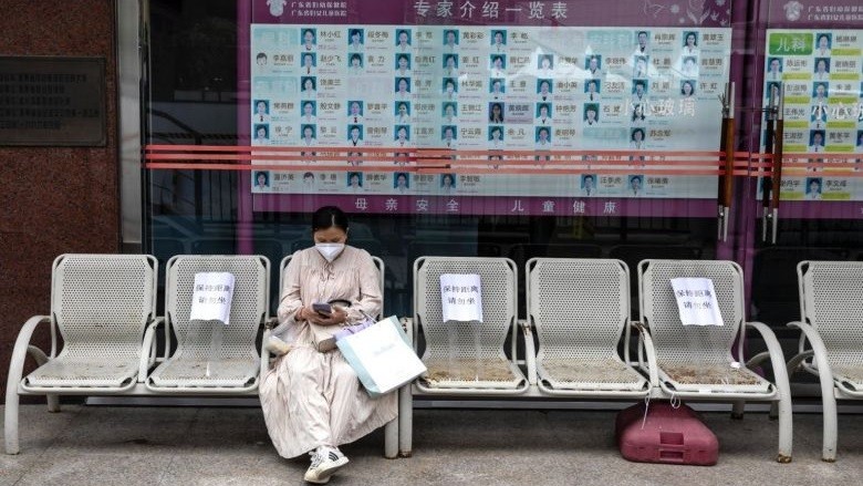 Một phụ nữ ngồi trước bệnh viện chờ kết quả xét nghiệm  tại Quảng Châu, tỉnh Quảng Đông, Trung Quốc. Ảnh: EPA-EFE