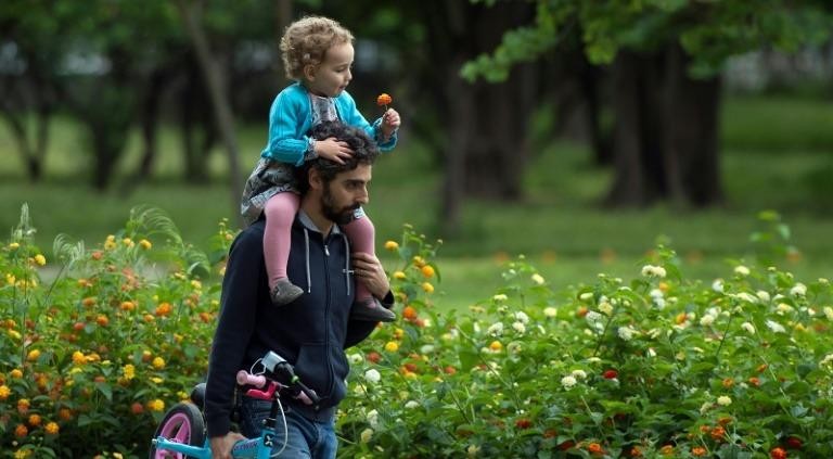 Một người cha công kênh cô con gái nhỏ trên vai trong công viên ở Seville, Tây Ban Nha, ngày 26/4/2020. Ảnh: AFP.