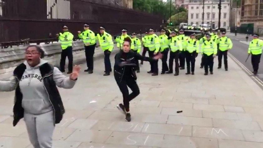 Hai người phụ nữ đứng giữa ngăn người biểu tình tấn công các cảnh sát đang rút lui ở trung tâm London.