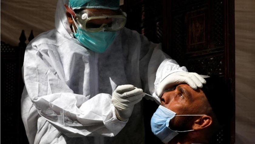 Một nhân viên y tế lấy mẫu bệnh phẩm mũi để xét nghiệm COVID-19, tại Karachi, Pakistan. Ảnh: Reuters.