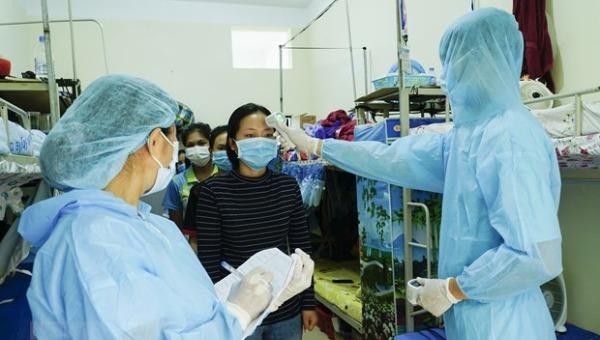 Nhân viên y tế đo thân nhiệt và kiểm tra sức khỏe cho các lưu học sinh Lào. Ảnh: Xuân Tư/TTXVN.