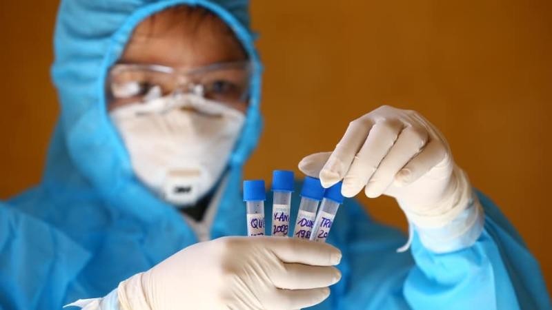 Nhân viên y tế lấy mẫu dịch hầu họng để xét nghiệm bằng phương pháp RT-PCR cho người dân trở về từ Đà Nẵng. (Ảnh: Minh Quyết/TTXVN)
