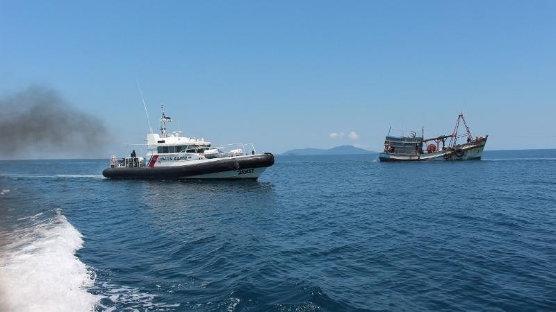 Tàu tuần tra của Malaysia áp tải tàu cá Việt Nam (phải) vào bờ - Ảnh: MMEA/Tuổi trẻ