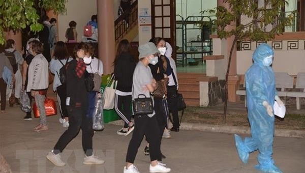 Nhân viên y tế hướng dẫn công dân trở về vào khu vực cách ly tại Tiền Giang. (Ảnh: Nam Thái/TTXVN)