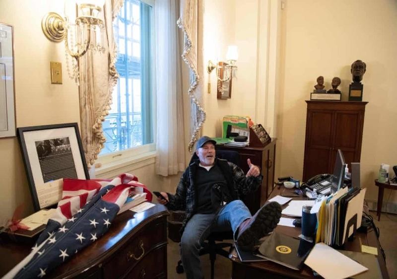 Bức ảnh  người ủng hộ ông Trump ngồi gác chân lên bàn làm việc trong văn phòng của Chủ tịch Hạ viện Nancy Pelosi tại tòa nhà Quốc hội Mỹ, ngày 6/1.