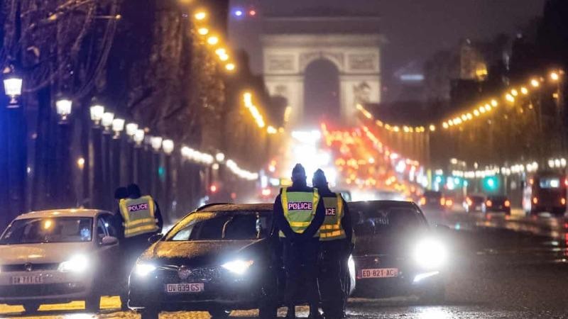 Cảnh sát đang kiểm soát thực thi lệnh giới nghiêm tại một trạm kiểm soát trên đại lộ Champs-Élysées (Paris, Pháp). Ảnh: EPA