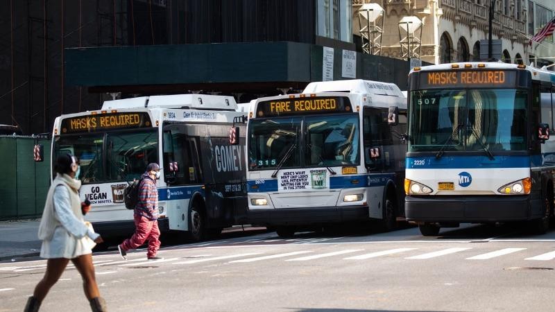 Xe buýt có biển báo "Bắt buộc phải đeo khẩu trang" ở New York. Ảnh: Bloomberg