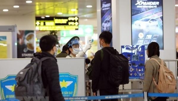 Kiểm tra thân nhiệt của hành khách ở sân bay Nội Bài. Ảnh: Huy Hùng/TTXVN.