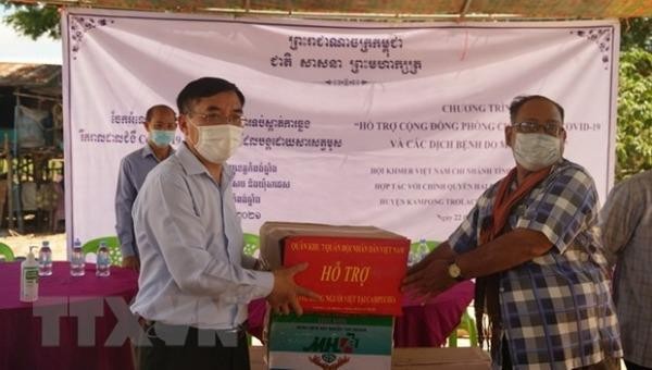 Công sứ sứ quán Việt Nam tại Campuchia Lại Xuân Chiến (trái) trao tặng vật tư y tế chống dịch cho đại diện chính quyền hai xã Saeb và Ta Ches, huyện Kampong Trolach. Ảnh: Trần Long/TTXVN.