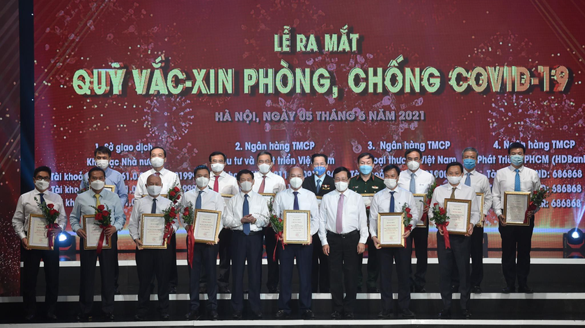Phó Thủ tướng Phạm Bình Minh, Bộ trưởng Bộ Tài chính Hồ Đức Phớc và đại diện bộ ngành, DN đóng góp cho Quỹ vaccine phòng chống COVID-19. Ảnh VGP.
