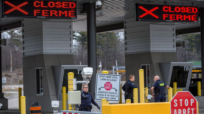 Các nhân viên Cơ quan Dịch vụ Biên giới Canada đứng trước hai trạm kiểm soát đã bị đóng cửa tại cửa khẩu biên giới Hoa Kỳ-Canada (Ảnh: REUTERS / Alex Filipe)