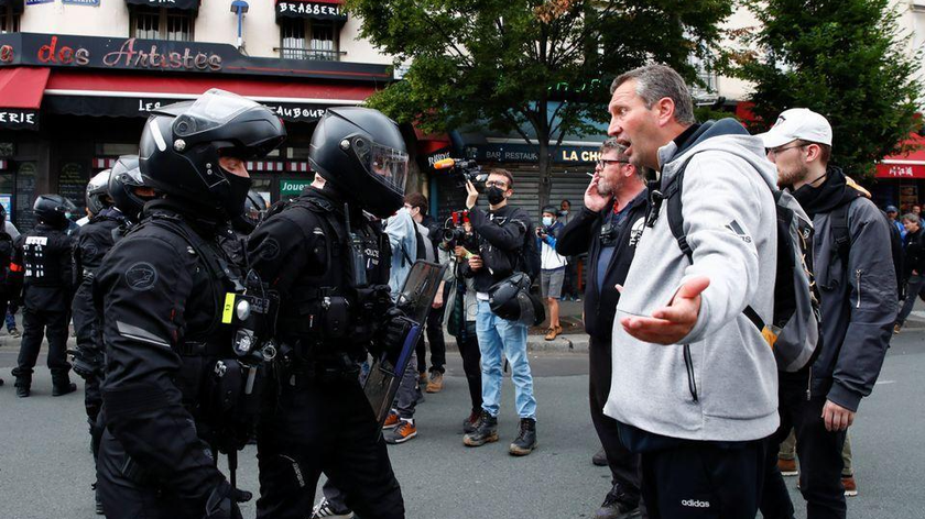 Người dân Paris tranh cãi với các sĩ quan cảnh sát trong cuộc biểu tình phản đối các biện pháp mới do Tổng thống Pháp Emmanuel Macron công bố nhằm chống lại COVID-19 (Ảnh: REUTERS)