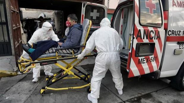 Nhân viên y tế chuyển bệnh nhân nhiễm COVID-19 lên xe cứu thương tại Toluca, Mexico. (Ảnh: AFP/TTXVN)