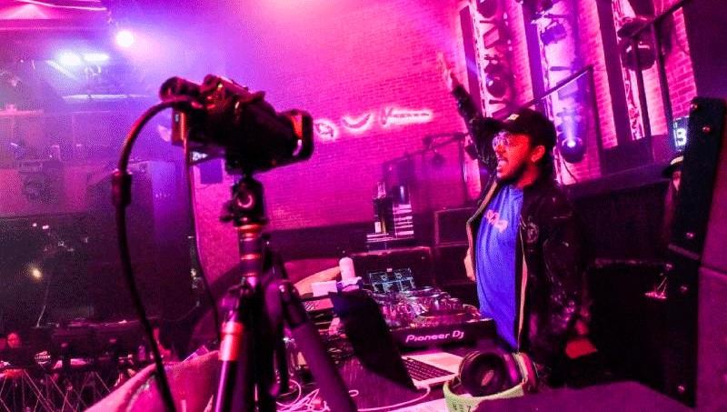 DJ Nash D biểu diễn trước máy quay được phát trực tiếp từ một quán bar ở Singapore. Ảnh: AFP.