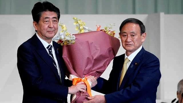 Thủ tướng Shinzo Abe tặmnh hoa cho ông  Yoshihide Suga vào ngày 14/9. Ảnh: REUTERS.